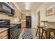 Efficient kitchen with black appliances, light wood cabinets, breakfast bar, and a modern black and white rug at 3472 Essex Ave # 81, Atlanta, GA 30339
