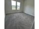 A bright bedroom with two windows and soft gray carpet flooring at 4011 Redan Rd # 8, Stone Mountain, GA 30083