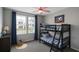 Bright bedroom featuring a bunk bed, ceiling fan, and large windows with bright blue curtains at 4011 Redan Rd # 8, Stone Mountain, GA 30083