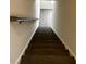 Modern stairway with dark wooden treads, white risers, and a sleek metal handrail, leading to the upper levels at 4011 Redan Rd # 8, Stone Mountain, GA 30083