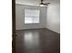 Bedroom features hardwood floors, a ceiling fan, and a large window with horizontal blinds at 1047 Plantation Way, Kennesaw, GA 30301