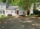 Charming single-Gathering home features a red door, traditional shutters, and mature trees in the front yard at 1047 Plantation Way, Kennesaw, GA 30301