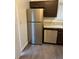Stainless steel refrigerator and dishwasher complementing the granite countertop and dark cabinets for a modern kitchen at 1047 Plantation Way, Kennesaw, GA 30301
