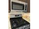Modern stainless steel microwave and gas cooktop with granite countertops for a sleek cooking experience at 1047 Plantation Way, Kennesaw, GA 30301
