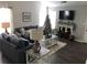 Cozy living room with fireplace, large TV, wood floors, and ample seating with neutral tones at 1047 Plantation Way, Kennesaw, GA 30301