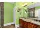 Bathroom showcasing double vanities, granite countertops, decorative mirror and green painted walls at 396 15Th Nw St # 6, Atlanta, GA 30318