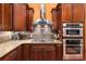 Close-up of the kitchen featuring dark wood cabinets, granite countertops, and stainless steel appliances at 396 15Th Nw St # 6, Atlanta, GA 30318