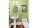 This powder room features a pedestal sink, toilet, and green walls at 396 15Th Nw St # 6, Atlanta, GA 30318