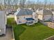 Aerial view features a spacious backyard with a covered patio, surrounded by lush greenery, fencing, and neighboring houses at 5180 Mirror Lake Dr, Cumming, GA 30028