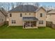 Spacious backyard featuring a well-maintained lawn, covered patio, and grilling area perfect for outdoor entertaining at 5180 Mirror Lake Dr, Cumming, GA 30028