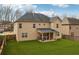 Expansive backyard featuring lush green grass, privacy fencing, and a covered patio at 5180 Mirror Lake Dr, Cumming, GA 30028