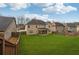 Expansive backyard featuring lush green grass, privacy fencing, and a covered patio at 5180 Mirror Lake Dr, Cumming, GA 30028