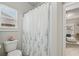 Cozy bathroom featuring a floral shower curtain, toilet, and a window with natural light at 5180 Mirror Lake Dr, Cumming, GA 30028