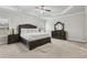 Elegant Primary bedroom with tray ceiling, large bed, dresser, and two windows at 5180 Mirror Lake Dr, Cumming, GA 30028