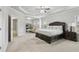 A beautiful main bedroom with decorative pillows, tray ceiling, and access to the living room at 5180 Mirror Lake Dr, Cumming, GA 30028