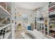 Bright walk-in closet featuring custom shelving, a chaise lounge, and ample space for shoes and accessories at 5180 Mirror Lake Dr, Cumming, GA 30028