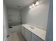 Modern bathroom features a white vanity with a sink and a shower-tub combo with shelving at 1006 Starmoss Lane, Conyers, GA 30094