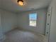This bedroom features a window, neutral walls, and a ceiling light fixture at 1006 Starmoss Lane, Conyers, GA 30094