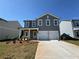 Charming new construction home with a gray facade, a two-car garage, and freshly landscaped yard at 1006 Starmoss Lane, Conyers, GA 30094
