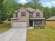 Charming two-story brick home with a well-manicured lawn and a cozy front porch seating area at 11028 Southwood Dr, Hampton, GA 30228