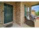 Inviting front porch with cozy seating, brick facade, and a welcoming entrance door at 11028 Southwood Dr, Hampton, GA 30228