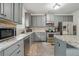 Charming kitchen featuring stainless steel appliances, gray cabinets, granite countertops and hardwood floors at 11028 Southwood Dr, Hampton, GA 30228