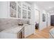 Home bar area with glass-front cabinets, wine fridge, and granite countertop provides a stylish place to relax at 281 Abbott Dr, Canton, GA 30114