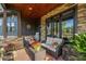 Cozy covered porch with stone details, outdoor seating, wood ceiling, and garden view at 281 Abbott Dr, Canton, GA 30114