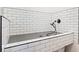 Tiled dog washing station with handheld shower and metal grate flooring at 281 Abbott Dr, Canton, GA 30114