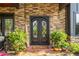 Elegant front entrance with double doors, stone accents, and manicured plants enhancing curb appeal at 281 Abbott Dr, Canton, GA 30114