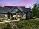A picturesque home at dusk features stone accents, a covered porch, and colorful landscaping at 281 Abbott Dr, Canton, GA 30114