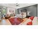 Spacious main bedroom with a four-poster bed, hardwood floors, accent wall, and a sitting area at 281 Abbott Dr, Canton, GA 30114