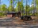 A small chicken coop and tractor sit on property with mature trees and natural landscape at 281 Abbott Dr, Canton, GA 30114
