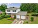 Two-story brick and white house with a two-car garage and manicured landscaping at 3909 Ebenezer Rd, Marietta, GA 30066