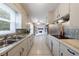 Efficient galley kitchen with white cabinets, stainless appliances, and classic tiled flooring at 3909 Ebenezer Rd, Marietta, GA 30066