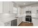 Well-lit kitchen showcasing white cabinetry, stainless steel appliances, and sleek countertops at 488 Village Ln, Fairburn, GA 30213