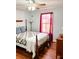 Cozy bedroom featuring a ceiling fan, hardwood floors, and a comfortable bed with stylish quilt and red curtains at 3809 Autumn View Nw Ln, Acworth, GA 30101