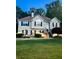 Charming two-story home with a well-manicured lawn, lush landscaping, and welcoming entrance stairs at 3809 Autumn View Nw Ln, Acworth, GA 30101