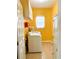Bright laundry room with washer, dryer, utility sink, storage cabinets, and a window, illuminated by golden walls at 3809 Autumn View Nw Ln, Acworth, GA 30101