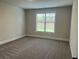 Bedroom featuring a window overlooking greenery, neutral walls, and plush carpeting at 4015 Sierra Vista Cir, Cumming, GA 30040