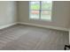 Bedroom featuring a window overlooking greenery, neutral walls, and plush carpeting at 4015 Sierra Vista Cir, Cumming, GA 30040