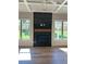 Cozy living room featuring hardwood floors, a striking black tile fireplace, and expansive windows overlooking the yard at 4015 Sierra Vista Cir, Cumming, GA 30040