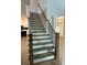 Elegant staircase with hardwood steps and black iron railings, leading to the upper level and kitchen at 4015 Sierra Vista Cir, Cumming, GA 30040