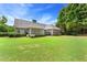 Spacious backyard featuring a well-manicured lawn, mature trees, and a charming screened-in porch at 4572 Mulberry Fields Ln, Auburn, GA 30011