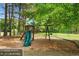 Community playground with slide and swings, surrounded by mature trees, perfect for recreation at 4572 Mulberry Fields Ln, Auburn, GA 30011