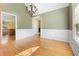 Dining room area features white wainscoting, hardwood floors, a chandelier, and an adjacent eat-in kitchen at 4572 Mulberry Fields Ln, Auburn, GA 30011