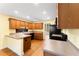 Cozy kitchen with stained cabinets, laminate counters, hardwood floors, black appliances, and yellow walls at 4572 Mulberry Fields Ln, Auburn, GA 30011
