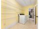 Bright laundry room with wire shelving, tile flooring, a large washer, and a doorway to the walk-in closet at 4572 Mulberry Fields Ln, Auburn, GA 30011