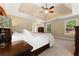 Comfortable main bedroom with natural lighting, neutral carpet, and a tray ceiling at 4572 Mulberry Fields Ln, Auburn, GA 30011