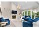 Bright living room showcases a fireplace, modern chandelier, and comfortable blue furniture at 4325 Acanthite Ct, Cumming, GA 30040